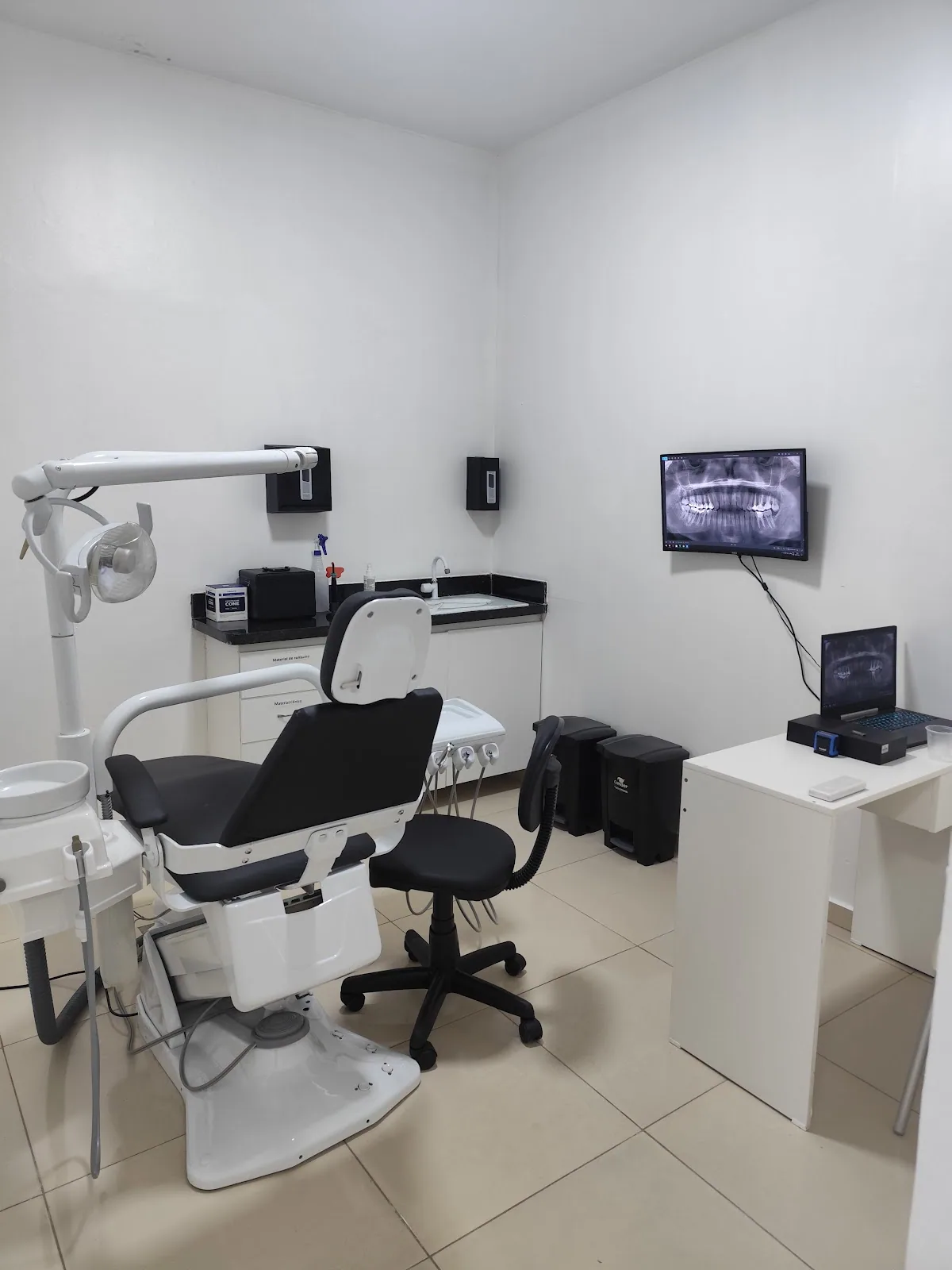 Consultório da Sorriso Perfeito com equipamento odontológico moderno e imagem de raio-x na tela